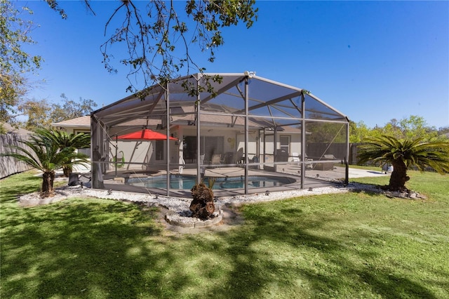 back of property featuring a yard, a patio area, fence, and an outdoor pool