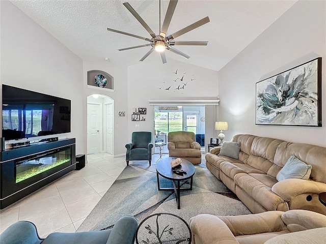 living room featuring arched walkways, light tile patterned floors, ceiling fan, a textured ceiling, and high vaulted ceiling