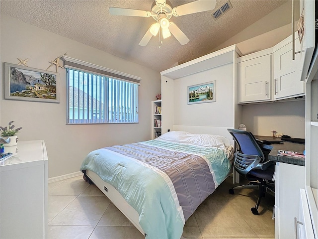 bedroom featuring lofted ceiling, light tile patterned floors, visible vents, and a textured ceiling