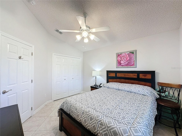 bedroom featuring light tile patterned floors, lofted ceiling, a closet, visible vents, and a ceiling fan