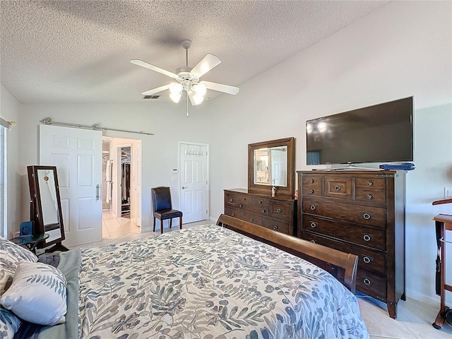 bedroom with visible vents, a barn door, a ceiling fan, vaulted ceiling, and a textured ceiling