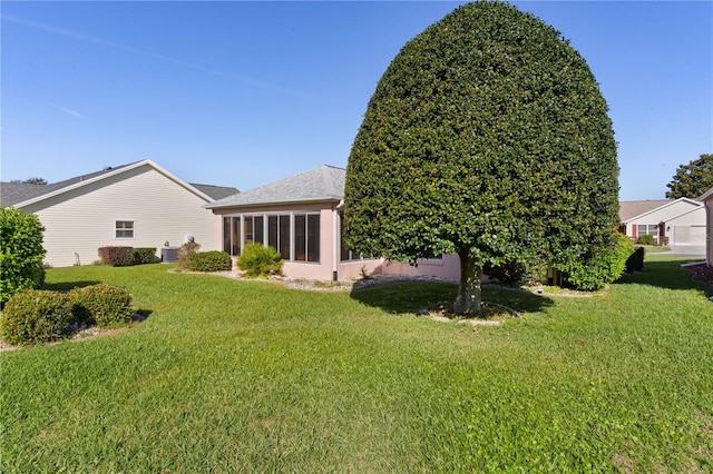 rear view of property with a sunroom and a lawn