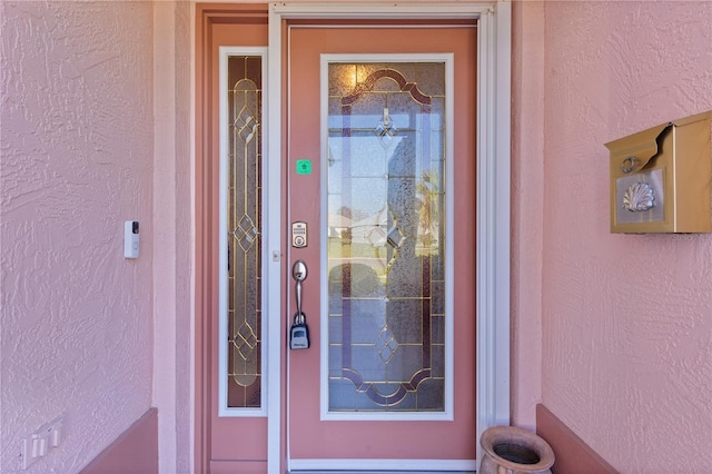 doorway to property featuring stucco siding