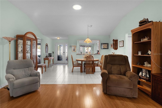 dining room with lofted ceiling and light wood finished floors