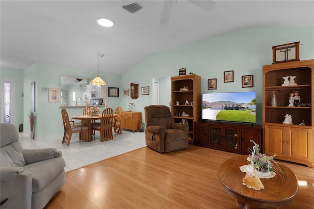 living room with lofted ceiling, ceiling fan, visible vents, and light wood-style flooring