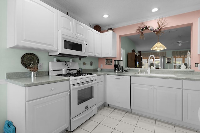 kitchen featuring white appliances, white cabinets, and a sink