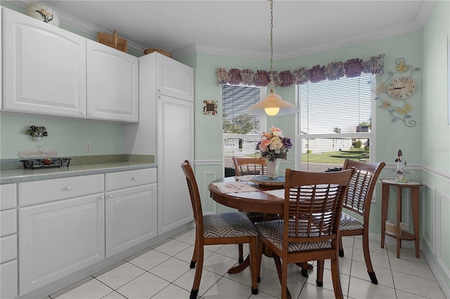 dining space featuring light tile patterned floors and crown molding