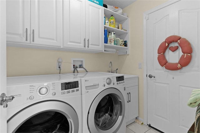 laundry room featuring light tile patterned flooring, cabinet space, and washer and dryer