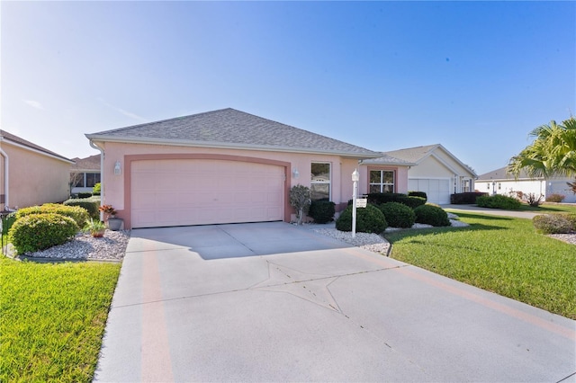 single story home featuring an attached garage, a front lawn, concrete driveway, and stucco siding