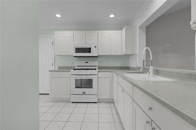 kitchen featuring light tile patterned flooring, white appliances, light countertops, white cabinets, and a sink
