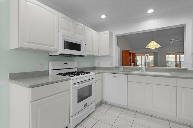 kitchen with a sink, hanging light fixtures, white appliances, and white cabinetry