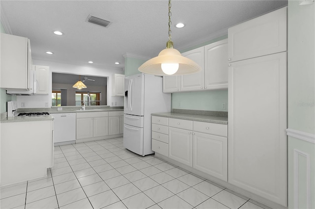 kitchen featuring white appliances, white cabinetry, decorative light fixtures, and visible vents