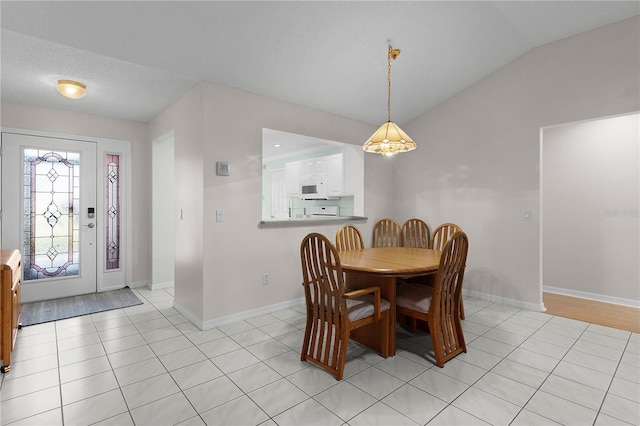 dining space with baseboards, vaulted ceiling, and light tile patterned floors