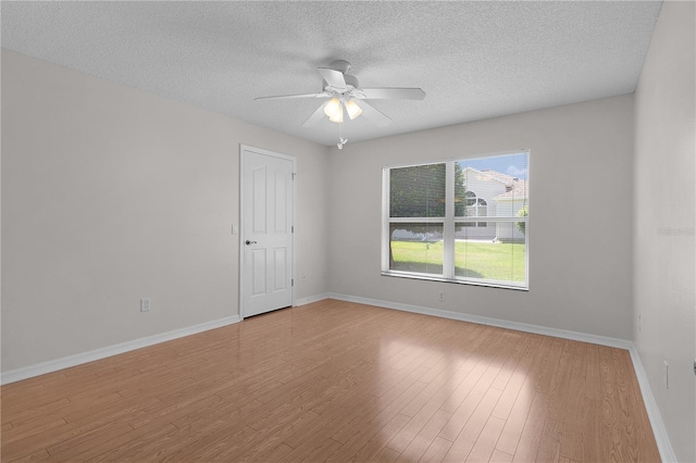spare room with baseboards, a ceiling fan, a textured ceiling, and wood finished floors