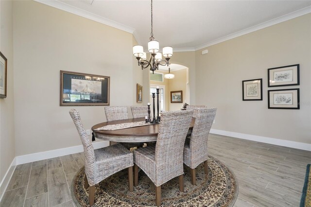 2124 Biller Cir, The Villages, FL 32163 - dining room with baseboards, arched walkways, crown molding, and wood finished floors