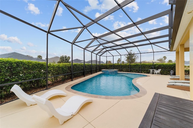 view of pool with glass enclosure, a patio, and a pool with connected hot tub