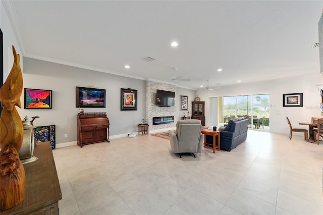 living room with visible vents, crown molding, baseboards, a stone fireplace, and recessed lighting