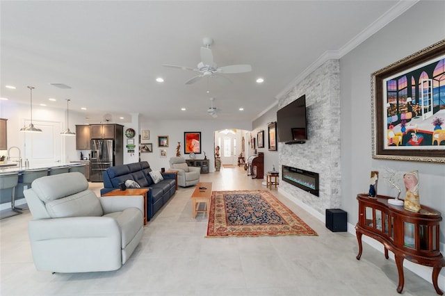 living area featuring crown molding, light tile patterned floors, recessed lighting, a fireplace, and a ceiling fan