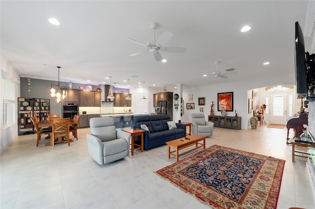 living room featuring ceiling fan with notable chandelier, recessed lighting, and visible vents