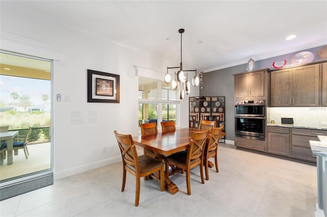 dining room featuring light tile patterned floors, baseboards, a chandelier, and crown molding