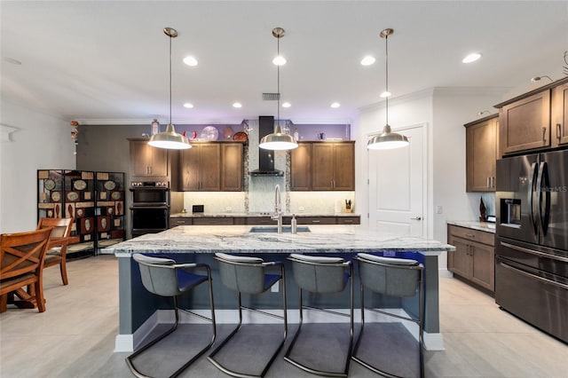 kitchen with crown molding, double oven, black fridge, wall chimney exhaust hood, and a sink