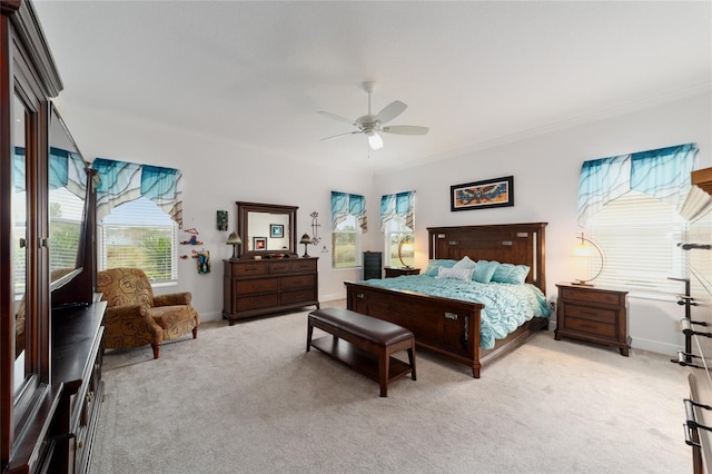 bedroom with light colored carpet, ceiling fan, baseboards, and ornamental molding