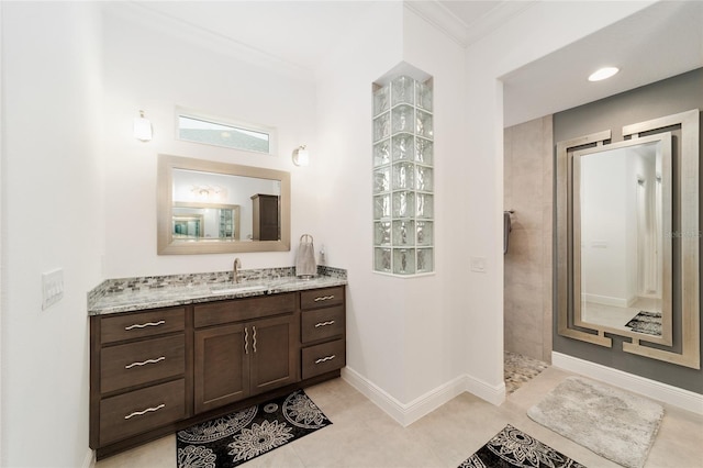 bathroom featuring crown molding, tile patterned flooring, baseboards, walk in shower, and vanity