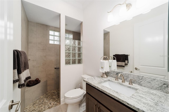 full bath featuring vanity, toilet, a walk in shower, and tile patterned flooring