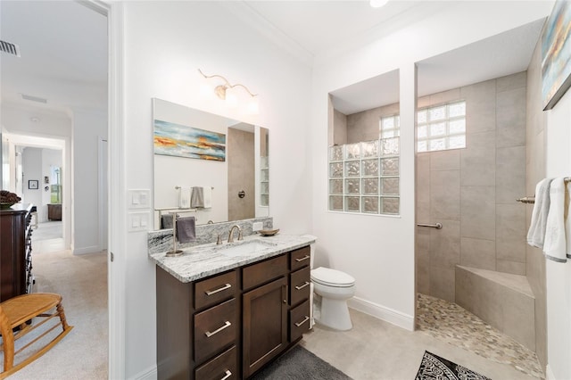 bathroom featuring vanity, baseboards, a walk in shower, crown molding, and toilet