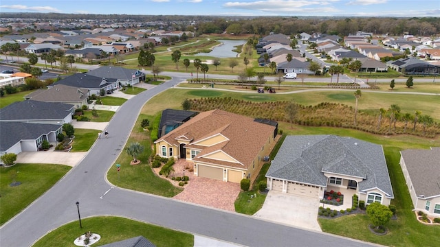 drone / aerial view with a residential view, view of golf course, and a water view