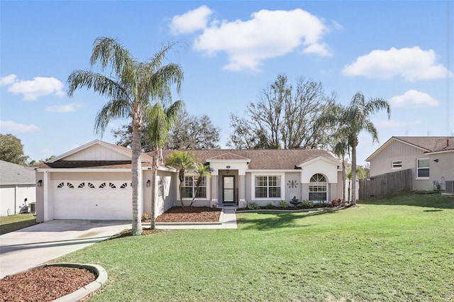 view of front facade with stucco siding, concrete driveway, fence, a garage, and a front lawn