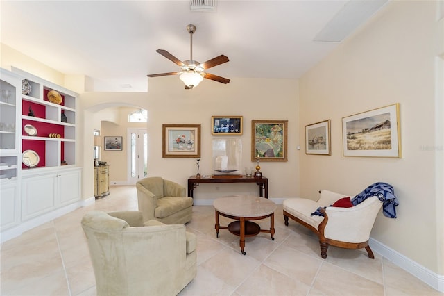 living room with arched walkways, visible vents, and light tile patterned floors