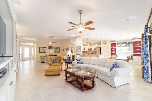 living area with light tile patterned floors, french doors, visible vents, and a ceiling fan