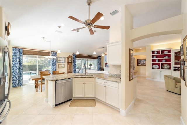 kitchen featuring visible vents, appliances with stainless steel finishes, light stone counters, a peninsula, and a sink