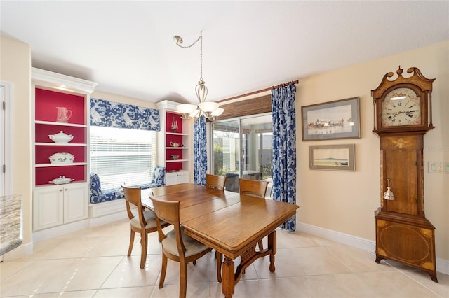 dining space featuring light tile patterned floors, baseboards, and a notable chandelier