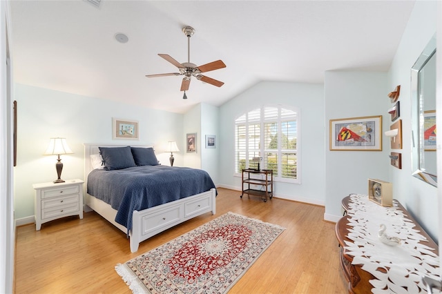 bedroom with lofted ceiling, light wood-style flooring, baseboards, and ceiling fan