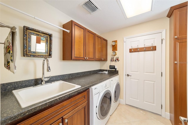 laundry area featuring light tile patterned flooring, separate washer and dryer, a sink, visible vents, and cabinet space