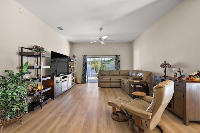 living room with ceiling fan, light wood finished floors, and visible vents