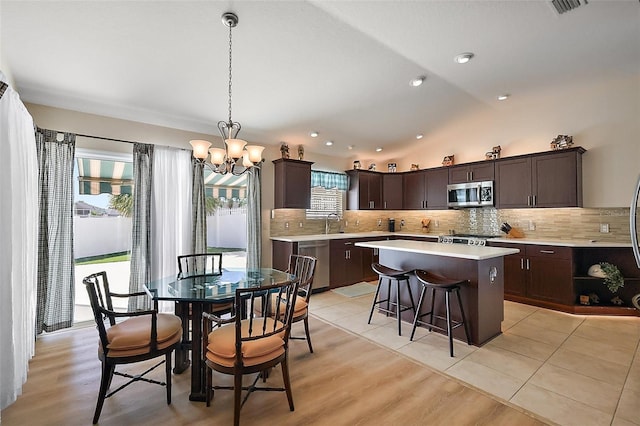 dining space featuring lofted ceiling, recessed lighting, visible vents, light wood-style flooring, and an inviting chandelier