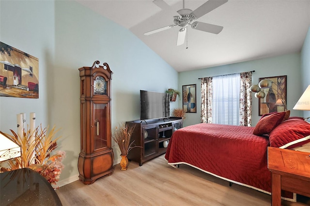 bedroom featuring lofted ceiling, a ceiling fan, and light wood-style floors