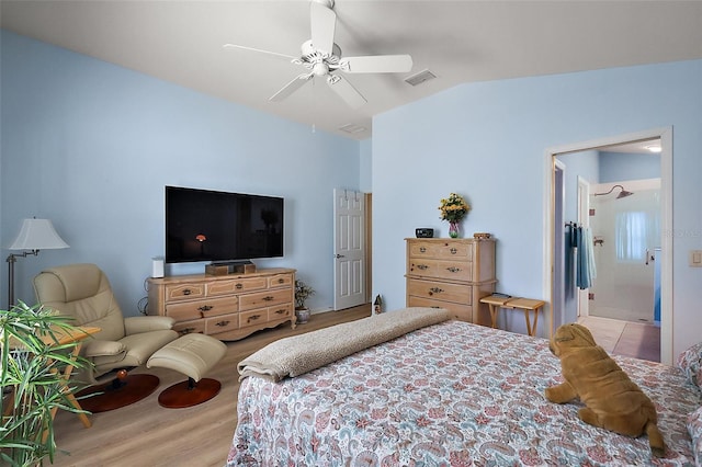 bedroom featuring ceiling fan, visible vents, vaulted ceiling, and wood finished floors