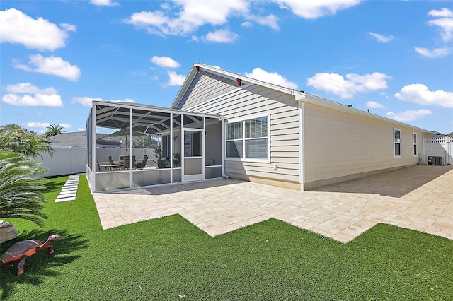 rear view of house with a sunroom, a patio area, and fence