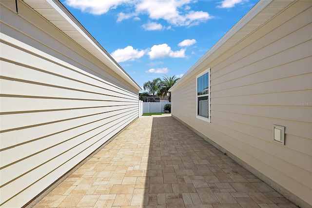 view of home's exterior with a patio area and fence