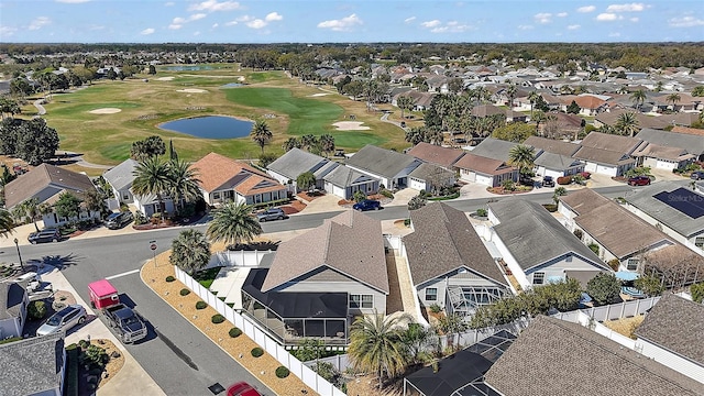 drone / aerial view featuring view of golf course, a water view, and a residential view