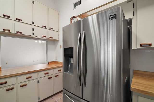 kitchen featuring white cabinets, visible vents, stainless steel fridge with ice dispenser, and light tile patterned floors