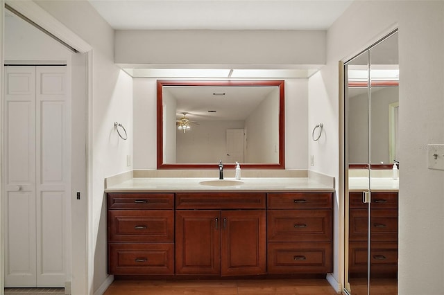 bathroom with ceiling fan, a closet, wood finished floors, and vanity