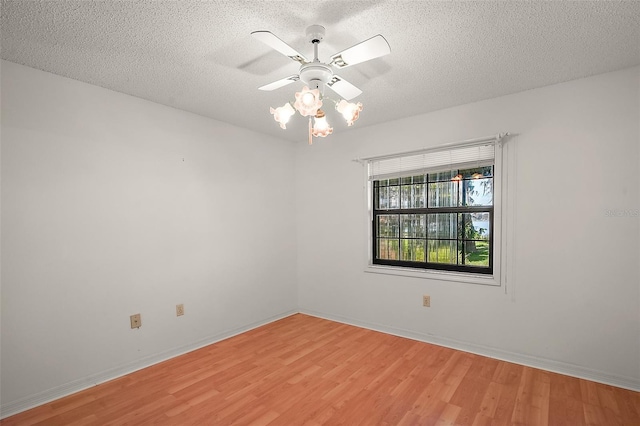 unfurnished room featuring light wood-type flooring, a textured ceiling, and baseboards