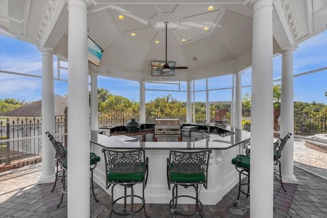 view of patio with fence, grilling area, exterior kitchen, and outdoor wet bar