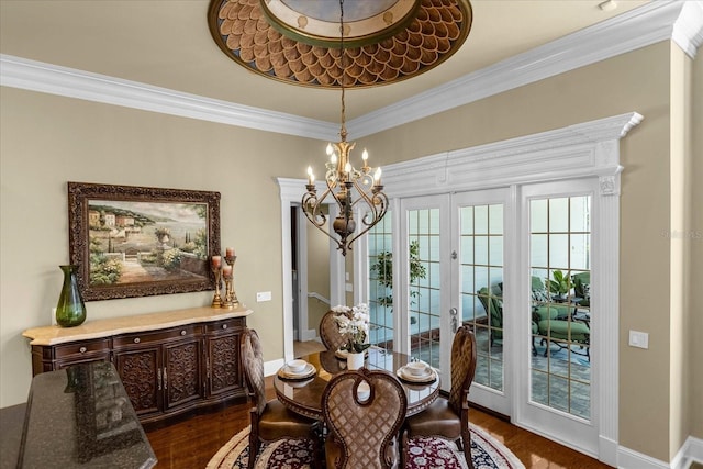 dining area featuring french doors, ornamental molding, dark wood-type flooring, a chandelier, and baseboards