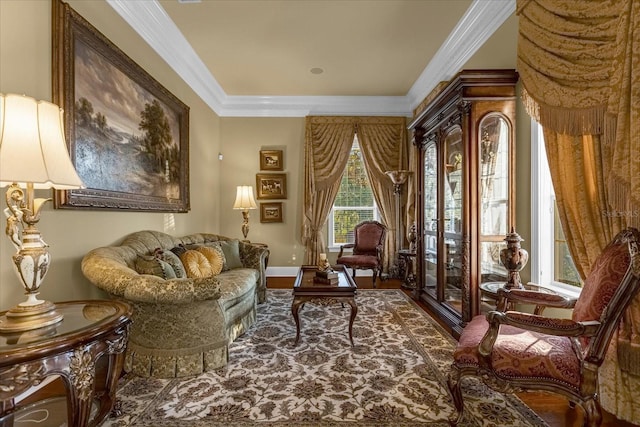 sitting room with ornamental molding and wood finished floors